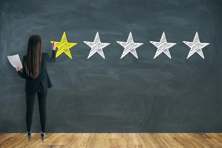 Businesswoman rating customer experience with a single yellow star on a chalkboard, illustrating UAE customer feedback